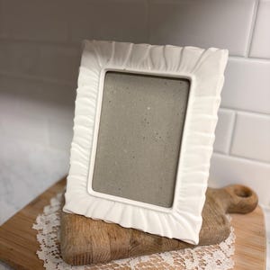 May include: A handmade wooden sign with the text "Welcome" in a playful font. The sign features a distressed white background and a dark brown frame, suitable for indoor or outdoor use.