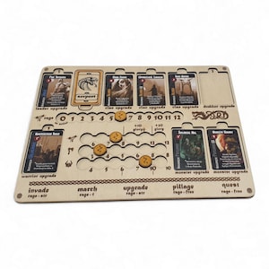 May include: A wooden board game organizer with slots for cards and tokens. The board features spaces for cards labeled "serpent", "clan upgrade", and "monster upgrade". It includes spaces for tokens and text like "invade" and "quest".