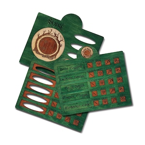 Pode incluir: Peças de jogo de madeira verde com a palavra "Shire" e um desenho circular de um buraco de hobbit. As peças do jogo têm ranhuras e texto com nomes como "Bilbo Baggins" e ícones relacionados com o jogo. As peças são de madeira.