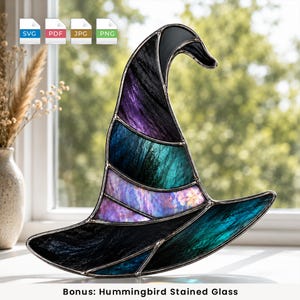 May include: A stained glass witch hat suncatcher featuring segmented panels of black, deep purple, and teal glass. The piece is constructed with dark metal solder lines and has a curved, pointed top section with a wide, flared brim base.