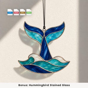 Op de afbeelding: Een glas-in-lood ornament in de vorm van een walvisstaart die uit oceaangolven komt, met tinten diepblauw, turkoois en wit glas verbonden door donkere metalen soldeerlijnen, opgehangen aan een zwart koord met SVG, PDF, JPG en PNG-pictogrammen.