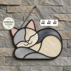 Op de afbeelding: Een gebrandschilderde kat in slaaphouding, met grijze, crèmekleurige en roze tinten. De kat is zwart omlijnd en hangt aan een ketting. De afbeelding bevat een "Commercial License"-badge en bestandstype-pictogrammen.