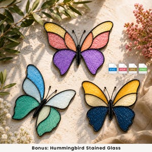 Peut inclure: Trois ornements en vitrail en forme de papillon avec des surfaces texturées et des contours en métal noir. Le papillon du haut a des ailes jaunes, roses, orange et violettes. Celui en bas à gauche a des ailes bleues, sarcelle et blanches. Celui en bas à droite a des ailes jaunes et bleu foncé.