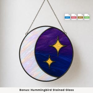 May include: A circular stained glass suncatcher featuring a crescent moon design. The moon is made of iridescent white glass, while the background is a deep purple and blue swirl. Two four-pointed gold stars are set within the dark sky section.