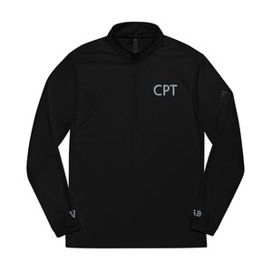 May include: Black long-sleeve athletic shirt with a quarter-zip collar. The shirt features the letters "CPT" in gray on the chest. Additional gray logos are visible on the sleeves. A sporty, comfortable top for workouts or casual wear.