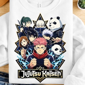 Può includere: Felpa bianca con una grafica colorata dei personaggi della serie anime Jujutsu Kaisen. Il design include più figure, un panda e il titolo della serie in un font stilizzato. La felpa è esposta su una superficie di legno.