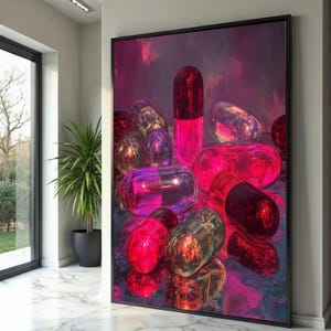 May include: A framed art print featuring a collection of large, translucent capsules in shades of red, pink, and purple. The capsules are arranged on a reflective surface, creating a vibrant and eye-catching display. The artwork is set against a dark, moody background.