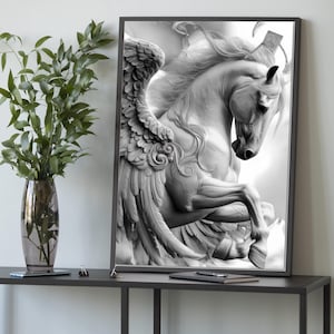May include: Black and white framed print of a rearing Pegasus, a mythical winged horse. The artwork features detailed feathering on the wings and flowing mane. The print is displayed on a dark gray table with a vase of greenery.