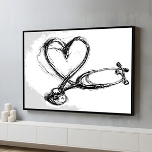May include: Black and white framed artwork featuring a stethoscope and a heart shape. The heart is formed with brushstrokes, and the stethoscope is detailed. The artwork is displayed on a white wall above a white cabinet.