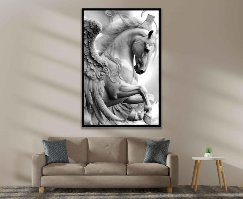 May include: Black and white framed print of a sculpted Pegasus, a mythical winged horse. The artwork features detailed wings and flowing mane, set against a bright background. The print is displayed above a beige sofa with blue pillows.