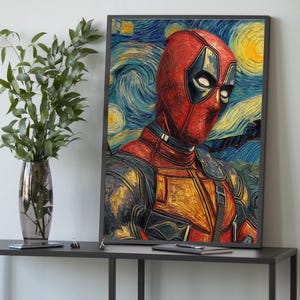 May include: Framed art print depicting Deadpool in a style inspired by Van Gogh's "Starry Night." The artwork shows Deadpool's red and black costume against a swirling blue and yellow background. The print is displayed on a dark grey table.