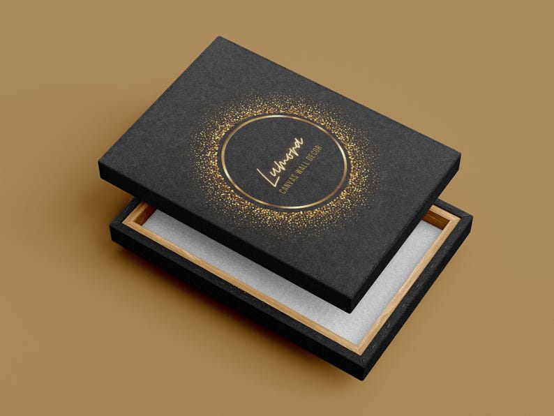 May include: Black box with a gold glitter design and the word "Lumora" in gold lettering. The box is open, revealing a white interior and a wooden frame. The words "Canvas Wall Design" are also visible.