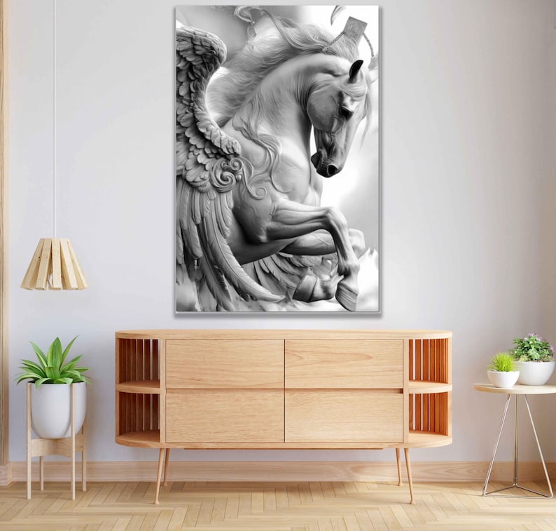 May include: A black and white canvas print of a sculpted Pegasus, a mythical winged horse. The artwork depicts the horse rearing up, showcasing detailed wings and flowing mane. The print is displayed above a wooden cabinet.