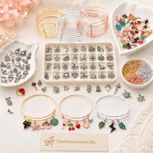 May include: A collection of jewelry-making supplies, including gold, silver, and rose gold bangles, charms, and chains. Charms include various shapes and colors, such as flowers, hearts, and leaves. The text "ThewhimsywonderGifts" is visible.