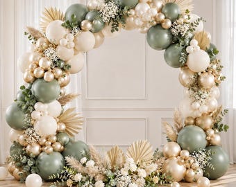 May include: A decorative balloon arch in a circular shape, featuring a mix of sage green, cream, and gold balloons. The arch is adorned with dried palm leaves, white flowers, and greenery, creating an elegant and festive display for events.