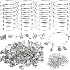 May include: A selection of silver-coloured jewellery-making components, including adjustable bangle bracelets, assorted charms, and jump rings. Charms include stars, keys, hearts, and leaves. Perfect for DIY jewellery projects.