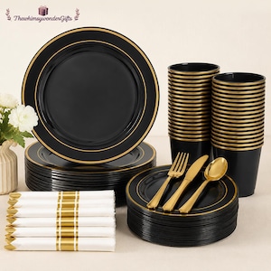 May include: A black and gold disposable dinnerware set. The set includes plates, cups, cutlery, and napkins. The plates and cups have a gold rim. The napkins are white with gold stripes. The cutlery is gold.