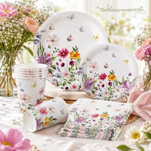 May include: A set of floral-themed party supplies, including plates, cups, and napkins. The white paper products are decorated with colorful flowers and butterflies. The plates are in two sizes, and the cups are stacked. The napkins are stacked in a neat pile.