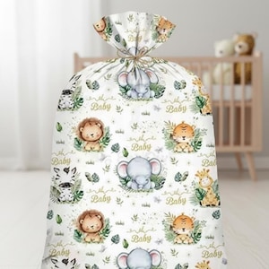 May include: A white gift bag with a jungle animal pattern. The bag features illustrations of a lion, elephant, zebra, tiger, and giraffe, with the word "Baby" repeated throughout. The bag is tied at the top with a natural twine.