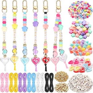 May include: Beaded keyrings in various colours, each with a name spelled out in gold letters. The keyrings have heart-shaped charms and tassels. Additional beads and craft supplies are also shown.