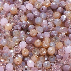 May include: A close-up view of a collection of faceted beads in various shades of pink, peach, and lavender. The beads are round with multiple facets, creating a sparkling effect. These beads are suitable for jewelry making and crafting.