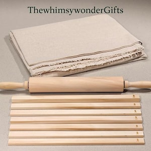 May include: A light beige linen cloth with frayed edges, a smooth wooden rolling pin, and a set of eight wooden dough thickness guides, each clearly marked with measurements in millimeters, labeled with the text ThewhimsywonderGifts.