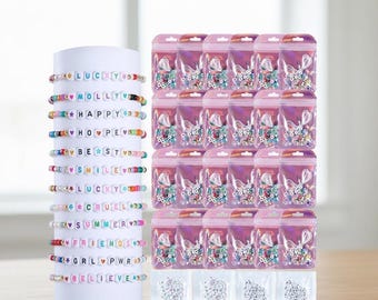 May include: A display of colorful beaded bracelets with various words and phrases, including "LUCKY," "MOLLY," and "FRIENDS." The bracelets are on a white cylinder. Also shown are small bags of beads and charms.