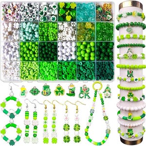 Peut inclure: Un assortiment de perles, breloques et composants de bijoux verts et blancs pour le bricolage. Comprend une variété de perles, boucles d'oreilles, bracelets et un collier. La palette de couleurs est principalement verte avec des accents blancs, avec des breloques sur le thème du trèfle et de la Saint-Patrick.