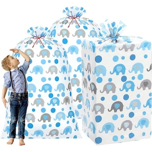 May include: White gift bags and a wrapped box, patterned with blue and grey elephants and blue polka dots. The bags are tied with blue and red ribbons. The theme is baby shower or children's gifts.