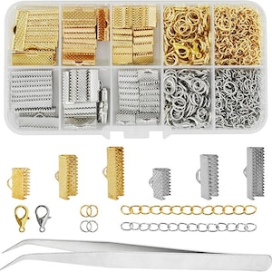 May include: A clear plastic organizer filled with various jewelry-making supplies. The compartments contain gold and silver clasps, jump rings, lobster clasps, and chain. A pair of silver tweezers is at the bottom.