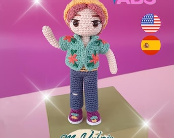 May include: A crocheted doll with a yellow hat, pink hair, and a teal jacket adorned with red flowers. The doll wears blue jeans and purple shoes. The image includes the text "ABS" and "Mr. Vulpis".