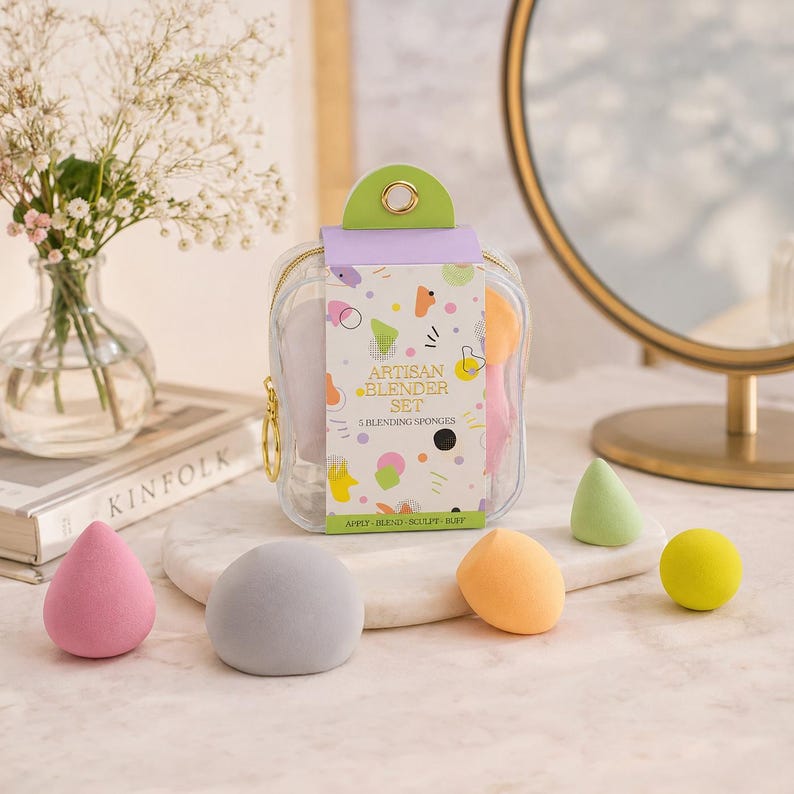 K&ouml;nnte beinhalten: Artisan Blender Set mit 5 Make-up-Schw&auml;mmen in einem transparenten Rei&szlig;verschlussetui. Das Set enth&auml;lt eine Vielzahl farbiger Schw&auml;mme in Rosa, Grau, Orange, Gr&uuml;n und Gelb. Der Text auf der Verpackung lautet "Artisan Blender Set".