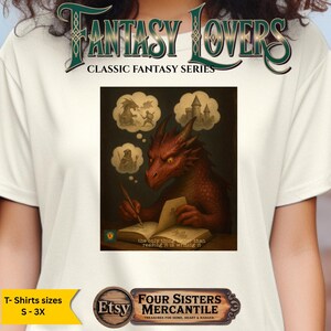 以下が含まれることがあります： クリーム色のTシャツ。ファンタジーアートプリントが施されています。赤いドラゴンが本を書いている様子が描かれており、城、魔法使い、騎士がドラゴンと戦っている様子が吹き出しで表現されています。「FANTASY LOVERS」と「CLASSIC FANTASY SERIES」の文字があります。