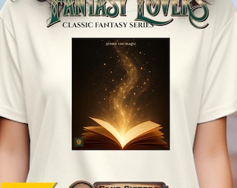Op de afbeelding: Crèmekleurig T-shirt met de tekst "FANTASY LOVERS" en "CLASSIC FANTASY SERIES". Het shirt toont een open boek met gloeiend licht en de woorden "create the magic". Het Etsy-logo en "FOUR SISTERS MERCANTILE" zijn ook zichtbaar.