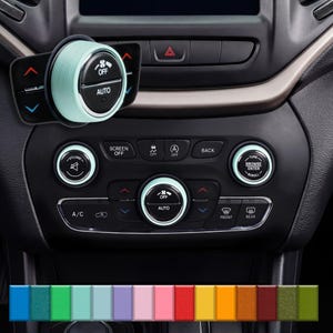 May include: A car dashboard with various buttons and controls. The image features a close-up of the climate control knobs and buttons, with a light teal accent color. The buttons include "OFF", "AUTO", "VOLUME", and "TUNE".