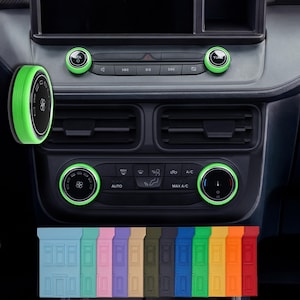 May include: A car dashboard with green accent rings around the knobs and buttons. The image shows a variety of colored trim pieces at the bottom. The car's interior is black.