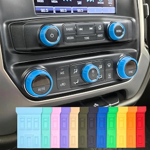 May include: Car interior with a black dashboard and blue accent rings around the radio and climate control knobs. A variety of colorful, house-shaped accessories are displayed at the bottom of the image.