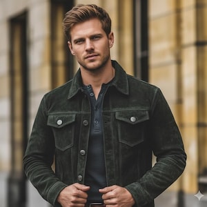 May include: A dark green suede jacket with button closures and two chest pockets. The jacket is worn over a gray polo shirt. The model is standing in front of a blurred background.