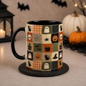 Peut inclure: Un mug en céramique avec une anse et un intérieur noirs, présentant un motif patchwork d'icônes d'Halloween incluant des fantômes, chats noirs, citrouilles, araignées, toiles, chaudrons, chapeaux de sorcière et maisons hantées en orange, vert et noir.