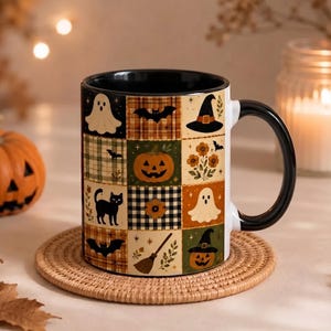 May include: A ceramic mug with a black handle and interior, featuring a grid pattern of Halloween-themed illustrations including ghosts, pumpkins, black cats, bats, witch hats, and brooms in shades of orange, black, green, and cream.