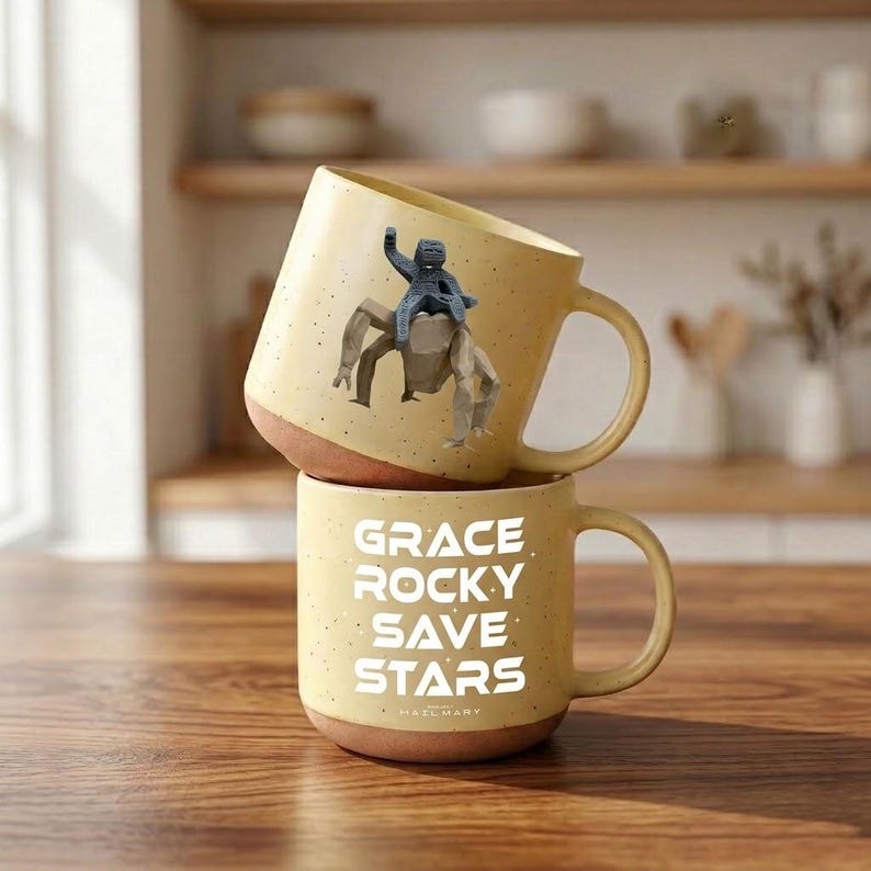 May include: A set of three ceramic mugs with a speckled, cream-colored glaze. Each mug features a different hand-painted floral design in shades of blue, green, and yellow. The mugs have a simple, rounded shape and a comfortable handle.