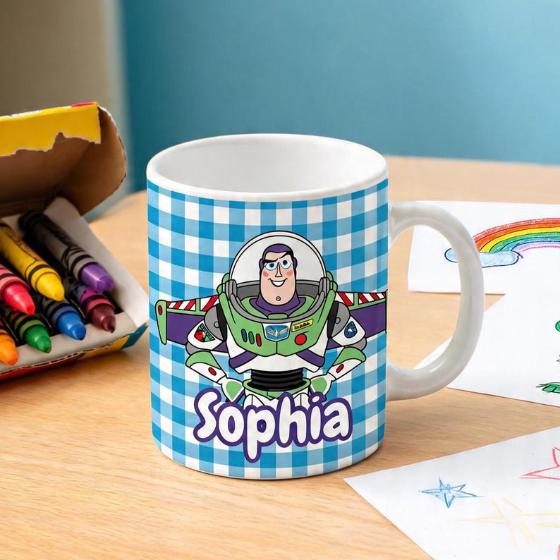 May include: A white ceramic mug featuring a blue and white checkered pattern background. The mug displays a graphic of the character Buzz Lightyear with the name Sophia printed in purple script lettering below the character on the front surface.