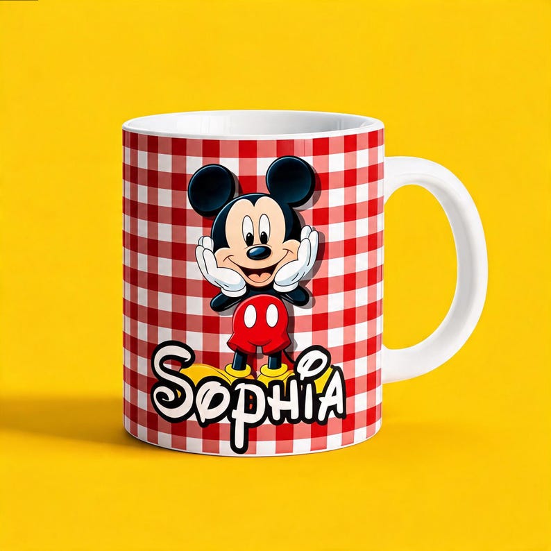 K&ouml;nnte beinhalten: Ein wei&szlig;er Keramikbecher mit einem rot-wei&szlig;en Karomuster. Auf der Vorderseite befindet sich eine Grafik von Mickey Mouse mit den H&auml;nden an den Wangen, platziert &uuml;ber dem Namen Sophia in einer fetten, wei&szlig;-schwarz umrandeten Schreibschrift.