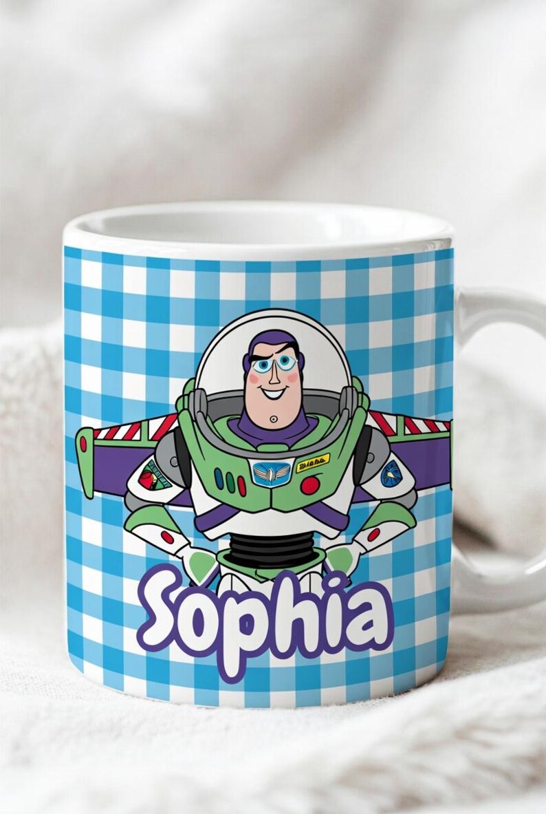 May include: A white ceramic mug featuring a blue and white checkered pattern background. The center displays a colorful illustration of the character Buzz Lightyear in his space suit. Below the character, the name Sophia is printed in purple text.