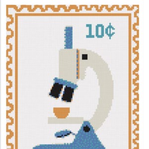 May include: A framed cross-stitch art piece featuring a microscope design on a postage stamp. The stamp has a light orange border and the text "10¢" in teal. The microscope is in shades of blue, beige, and black.