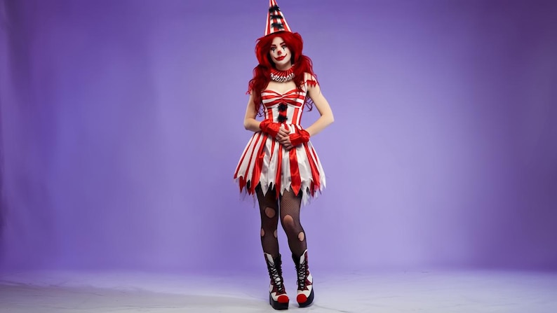 May include: A red and white striped clown costume with a matching hat, gloves, and boots. The dress has a tattered hemline, and the model is wearing black tights with holes. The background is a solid purple.