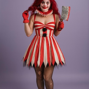 May include: A red and white striped clown costume with a matching hat, collar, and gloves. The dress has a flared skirt with a black trim. The clown is holding a prop axe and wearing black fishnet stockings and boots.