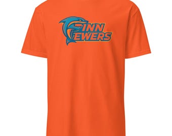 May include: Orange t-shirt with the text "Finn Ewer's" in blue and gold, featuring a dolphin graphic. The shirt is a short-sleeved crew neck style.