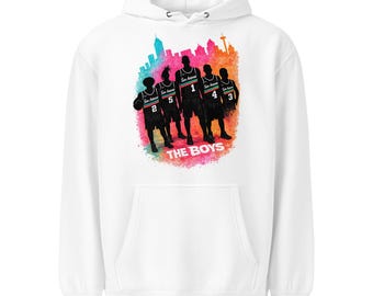 May include: White hoodie featuring a graphic of five basketball players in black silhouettes, with the text "THE BOYS" below. The design includes a colorful cityscape and player numbers. The hoodie has a front pocket and a hood.