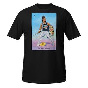 May include: Black t-shirt featuring a colorful illustration of a basketball player holding a sword and a scarf. The illustration includes the number 5, the words "San Antonio", and the text "EL VALIENTE".